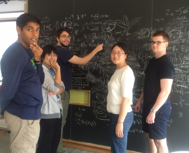 Graduates Writing on Black Board