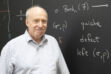 A headshot of Harvard mathematician Dan Freed standing in front of a blackboard covered with math formulas.