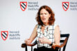 Harvard math professor Laura DeMarco sitting in a chair in front of a background with the Harvard Radcliffe Institute logo.